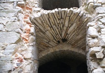 Konstrukcja okien. Zwraca uwagę wykorzystanie trzech rodzajów budulca: cegły, piaskowca i powszechnie dostępnego wapienia.