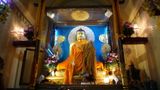 Mnich zmienia szatę Buddzie. Wnętrze świątyni Bothgaya. Zbz & Wallstreet