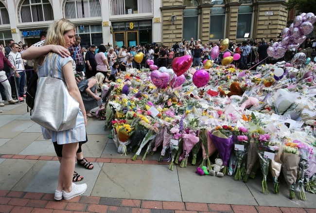 Ludzie modlą się za ofairy ataku w Manchesterze. fot.PAP/EPA/NIGEL RODDIS
