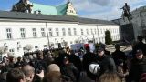 Parlamentarzyści PiS oddzieleni od zebranych ludzi barierkami i kordonem policji składają hołd ofiarom Tragedii Smoleńskiej