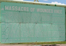 Tablica informująca o masakrze Wounded Knee. Widoczna tabliczka "Massacre" zakrywająca kłamliwe "Battle".