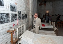 dr Jacek Żegliński ogląda wystawę w schronie, gdzie przed laty jego ojciec operował rannych powstańców_fot. Marcin Żegliński