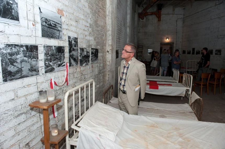 dr Jacek Żegliński ogląda wystawę w schronie, gdzie przed laty jego ojciec operował rannych powstańców_fot. Marcin Żegliński