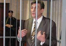 E Kaczanowski zeznaje na procesie na sali sądowej w specjalnej klatce z kratami. mającej go dodatkowo upokorzyć, 2011.