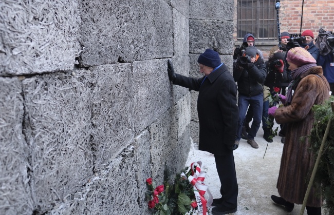 Byli więźniowie składają kwiaty i zapalają znicze pod Ścianą Śmierci. fot. PAP/Andrzej Grygiel