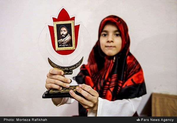 dziewczyna trzyma obrazek swojedo ojca szahida