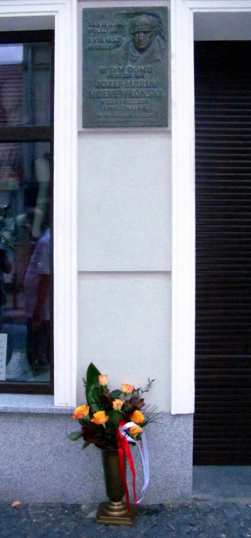 Kwiaty pod tablicą pamiątkową na domu w Wolsztynie, w którym 240 lat temu urodził się Józef Hoene.
