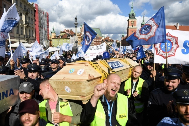 Protestujący niosą trumnę z napisem "policja",  fot. PAP/Radek Pietruszka