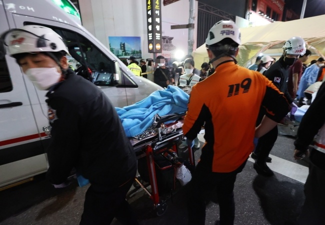 Ratownicy przenoszą ofiarę stratowania podczas imprezy Halloweenowej w Seulu, fot. PAP/EPA/YONHAP