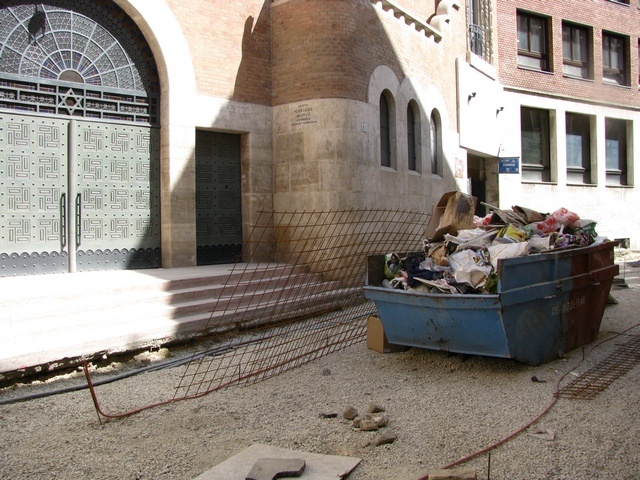 przylepiona do Synagogi restauracja - wejście a nad nim szyld - pojemnik dla urozmaicenia krajobrazu