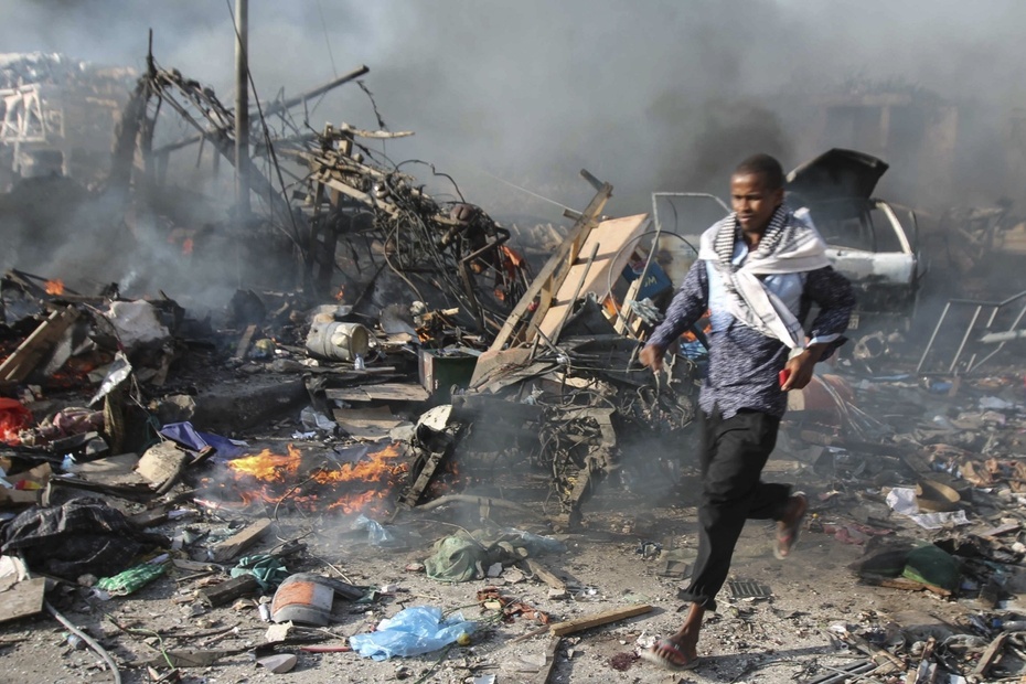 Mężczyzna przebiega przez miejsce eksplozji w Mogadiszu, fot. PAP/EPA/SAID YUSUF WARSAME