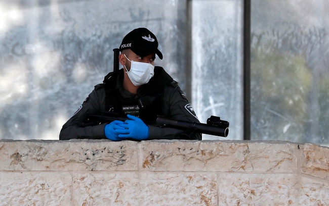 Koronawirus w Izrealu. Izraelski policjant w Jerozolimie. Fot. PAP/EPA/ATEF SAFADI