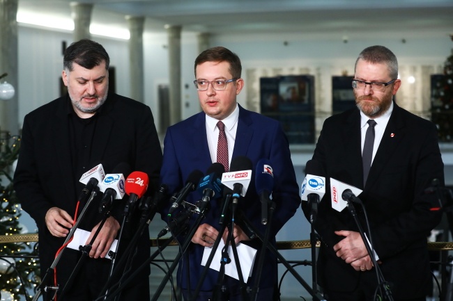 Posłowie Konfederacji: Robert Winnicki (C), Grzegorz Braun (P) i Artur Dziambor (L). Fot. PAP/Rafał Guz