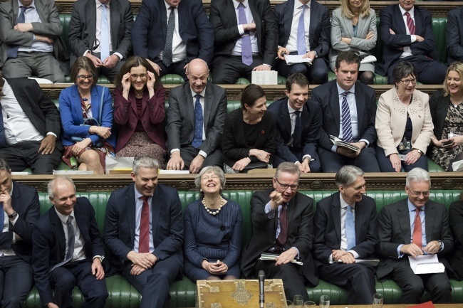 Theresa May śmieje się razem z ministrami i posłami po głosowaniu w Izbie Gmin, fot. PAP/EPA/JESSICA TAYLOR / UK PARLIAMENT