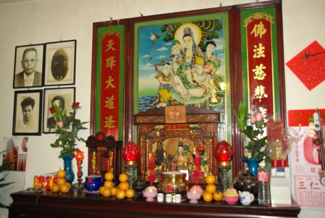 Ołtarz domowy.Po środku wizerunek bóstwa Guanyin, po lewej zdjęcia zmarłych, z przodu dary. Źródło:http://www.chiny.pl/sizu.php