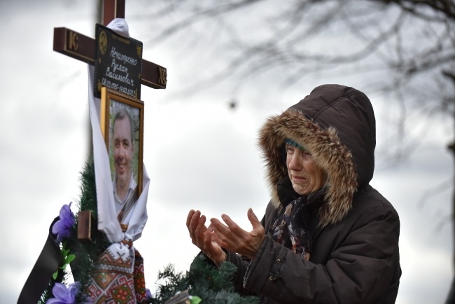Kobieta płacze nad grobem syna, którego zabili Rosjanie w Buczy, fot. PAP/EPA/OLEG PETRASYUK