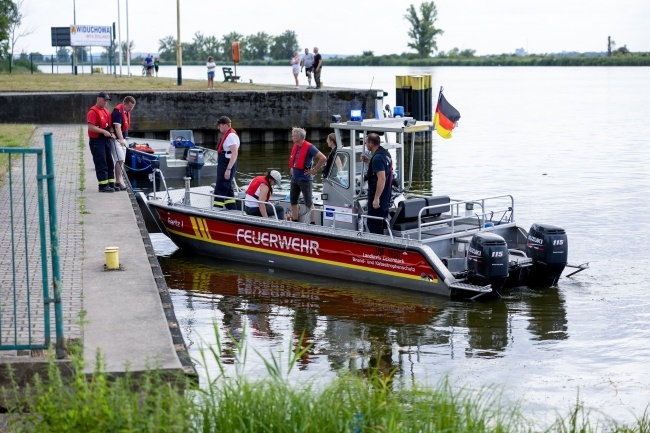 Strażacy ustawiają specjalną zaporę, której zadaniem będzie zatrzymywanie śniętych ryb płynących z nurtem Odry, fot. PAP/Marcin Bielecki