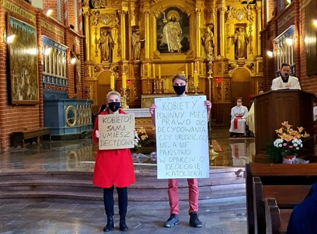 Joanna Scheuring-Wielgus protestuje w kościele św Jakuba w Toruniu, w którym 17 lat temu brała ślub z obecnym obok niej mężem, fot. Facebook/profil joanny Scheuring-Wielgus.