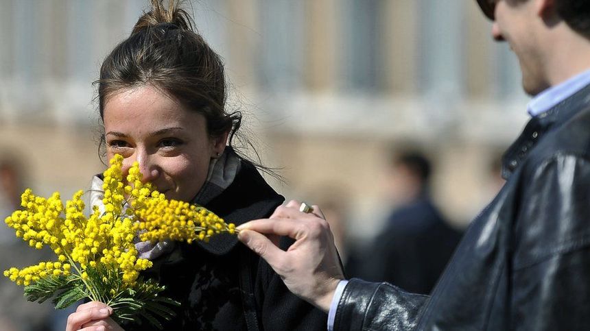 Getty images: A woman holds a bunch of mimosa in Rome on International Women's day 2012