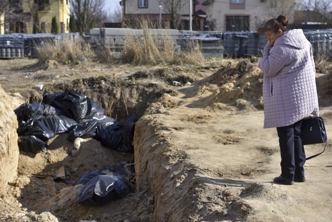 Kobieta przy masowym grobie w Buczy, fot. PAP/EPA/OLEG PETRASYUK