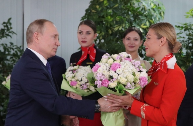 Putin wręcza kwiaty pracownicom Aeroflotu, fot. PAP/EPA/MIKHAEL KLIMENTYEV