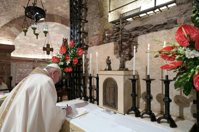 Papież Franciszek podpisuje encyklikę