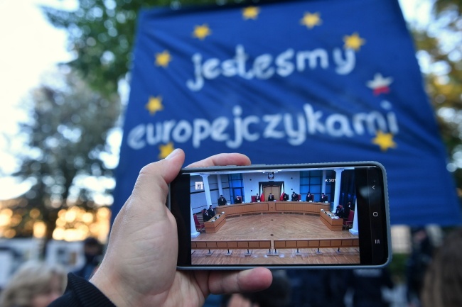 Obrady TK oglądane na ekranie telefonu przed siedzibą Trybunału Konstytucyjnego w Warszawie. Fot. PAP/Radek Pietruszka