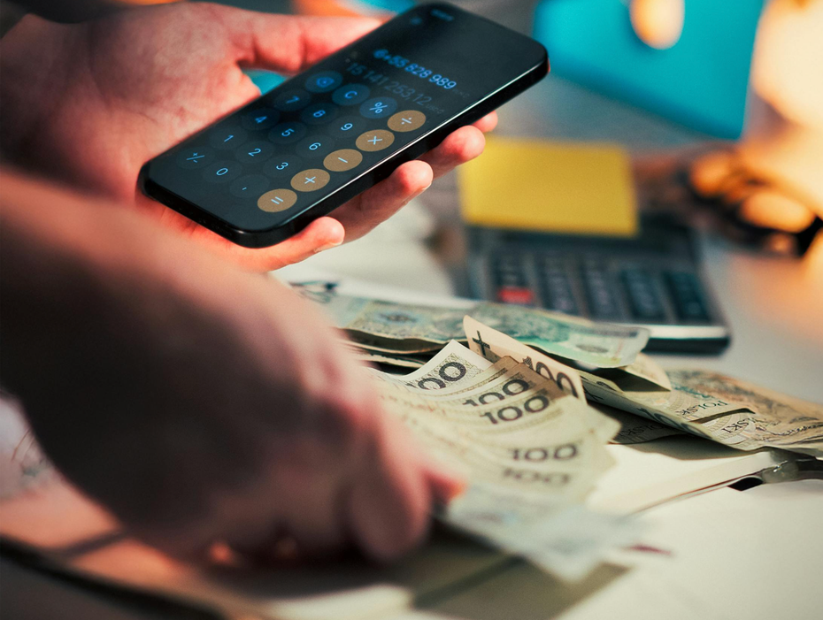 na zdjęciu: liczenie rachunków przy pomocy kalkulatora, polskie banknoty w walucie złoty. fot. Jakub Zerdzicki, Pexels