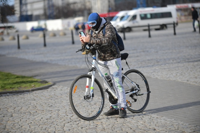 Rowerzysta zabezpieczający się przed zarażeniem koronawirusem przy pomocy okularów do nurkowania, 14 bm. na ulicy w Warszawie. Fot. PAP/Marcin Obara