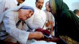 Mother Teresa presenting documents for a new house to a villager from Latur in Mumbai on September 2, 1994. (Photo: Reuters)