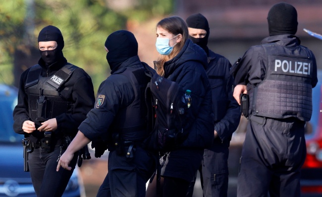 Niemiecka policja eskortuje podejrzanych do sądu. Fot. PAP/EPA/RONALD WITTEK