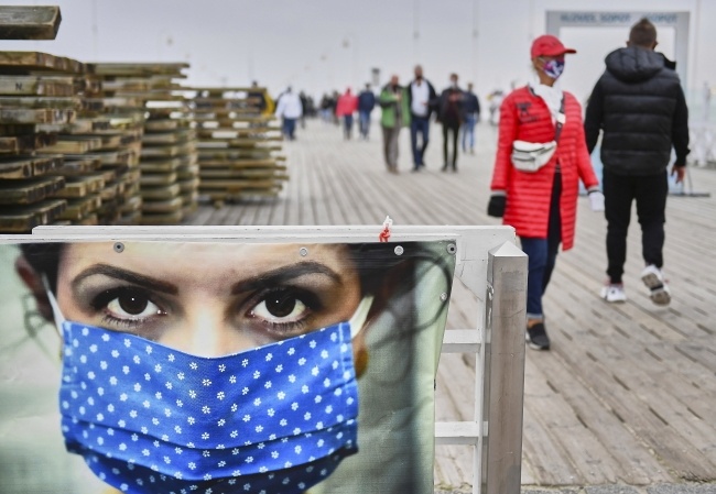 Plakat przy wejściu na molo w Sopocie, przypominający o obowiązku noszenia maseczek, fot. PAP/Adam Warżawa
