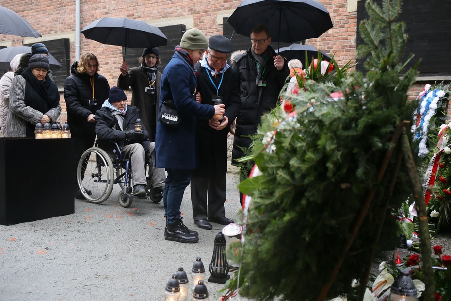 Złożenie kwiatów i zapalenie zniczy przed Ścianą Śmierci na terenie byłego niemieckiego nazistowskiego obozu koncentracyjnego i zagłady Auschwitz-Birkenau w Oświęcimiu, 27 bm., w dniu obchodów 79. rocznicy wyzwolenia obozu. 27 stycznia obchodzony jest Mię