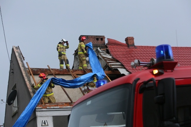 Strażacy i mieszkańcy zabezpieczają zniszczone dachy budynków po przejściu trąby powietrznej w miejscowości Dobrzyca, fot. PAP/Tomasz Wojtasik