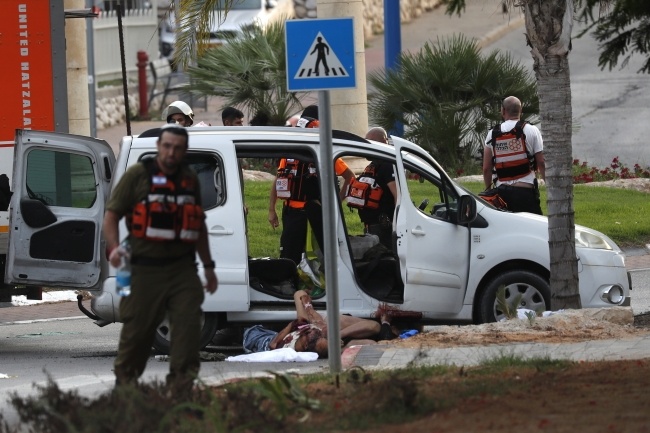 Policja izraelska zbiera trupy cywilów leżące na ulicach w Sderot, fot. PAP/EPA/ATEF SAFADI