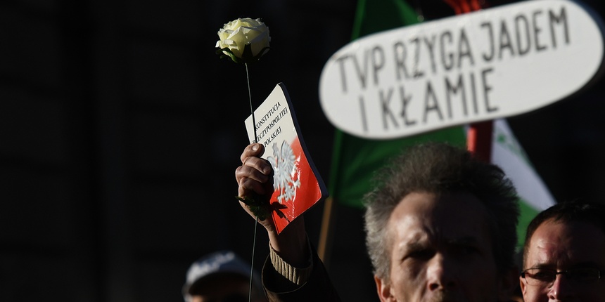An activist holds a copy of the Polish Constitution during a march against Polish state television (TVP), protesting media manipulation and creation of a propaganda machine accused of favoring the Law and Justice (PiS) ruling party, in Warsaw on Feb. 17. 