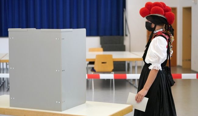 Kobieta w stroju ludowym głosuje w miejscowości Gutach, fot. PAP/EPA/RONALD WITTEK