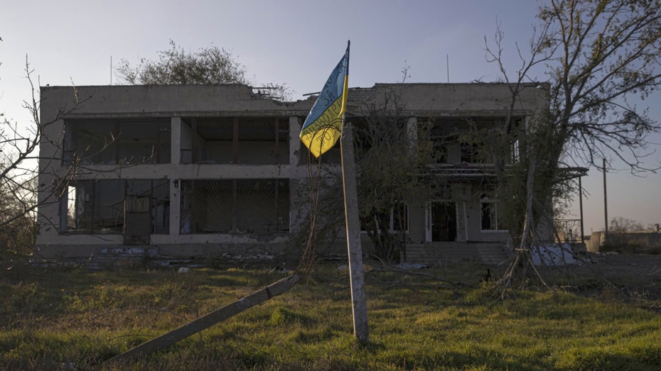 Ukraińska flaga przy ruinach budynku w Chersoniu, fot. Twitter