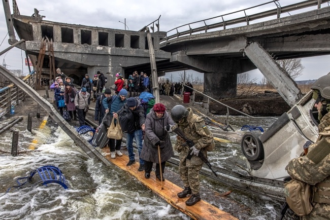 Mieszkańcy Irpienia próbują się przedostać przez zniszczony most. Fot. PAP/EPA/ROMAN PILIPEY