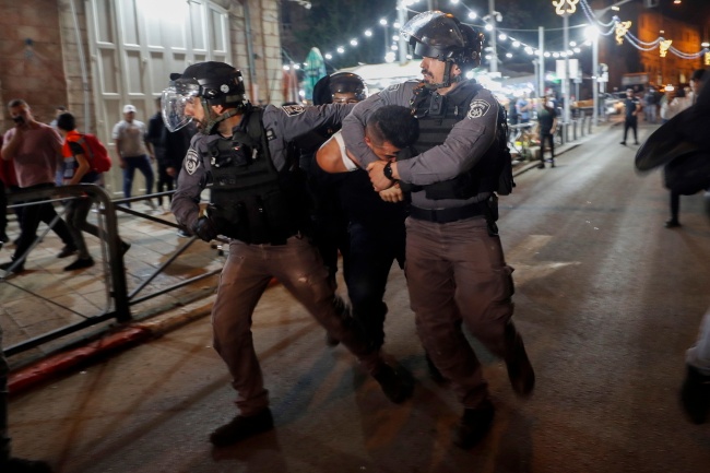 Jerozolima. Izraelscy policjanci obezwładniają Palestyńczyka. PAP/EPA/ATEF SAFADI