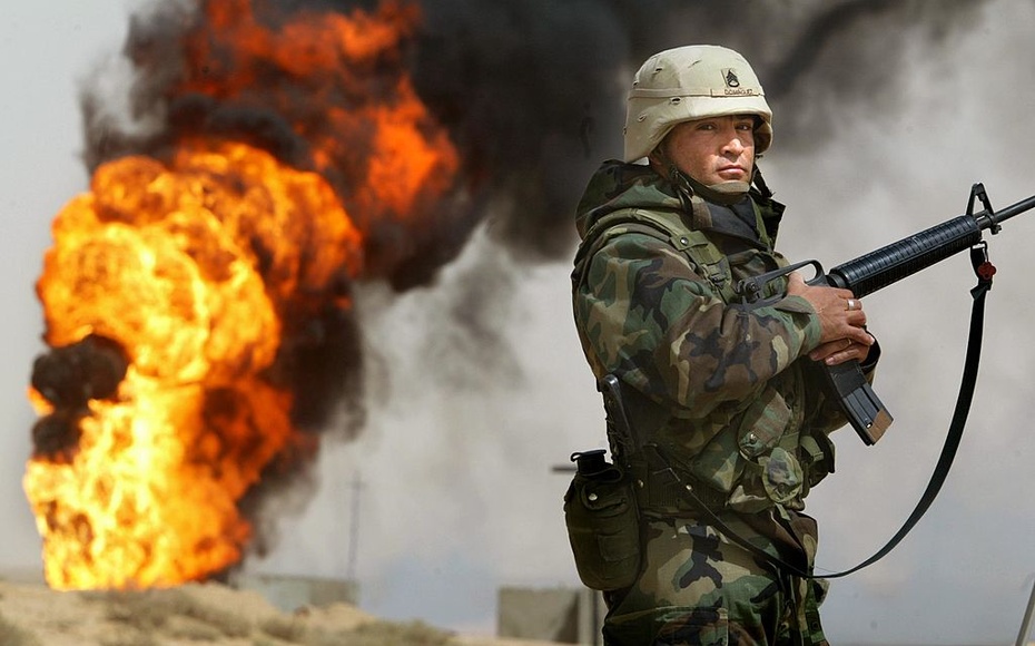 Amerykański żołnierz obok płonącego szybu naftowego w Iraku, 27.03.2003 (Mario Tama / Getty Images)