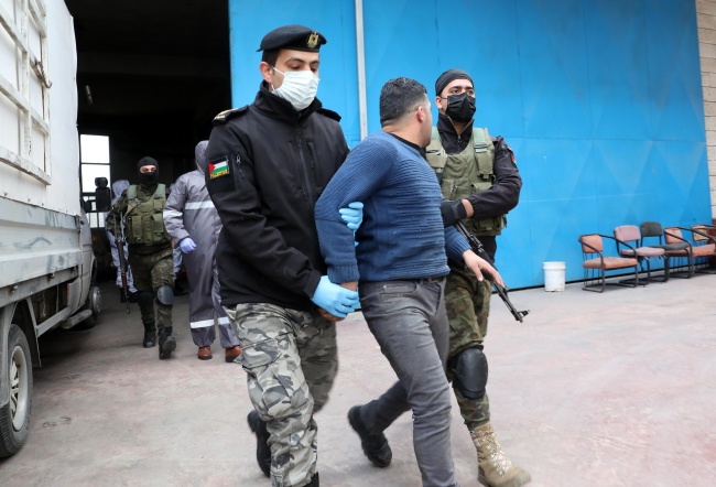 Palestyńscy żołnierze zatrzymali mężczyznę, który nie przestrzegał zasad kwarantanny. Fot. PAP/EPA/ABED AL HASHLAMOUN
