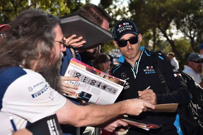 Robert Kubica rozdaje autografy swoim fanom.